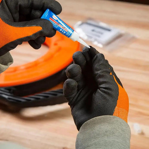 Hands applying glue to eyelet with Non Conductive Fish Tape Repair Kit For Fiberglass Tapes Made In USA on a workbench