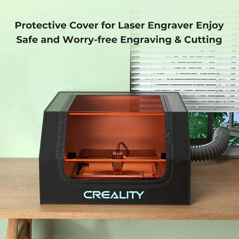 Laser Engraver Enclosure With Fireproof And Dustproof Protective Cover Built In Fan And Pipe For Most Laser Engravers 27.5x28.3x15.7In Reduces Smoke Odor Noise And Provides Eye Protection Creality shown on table.