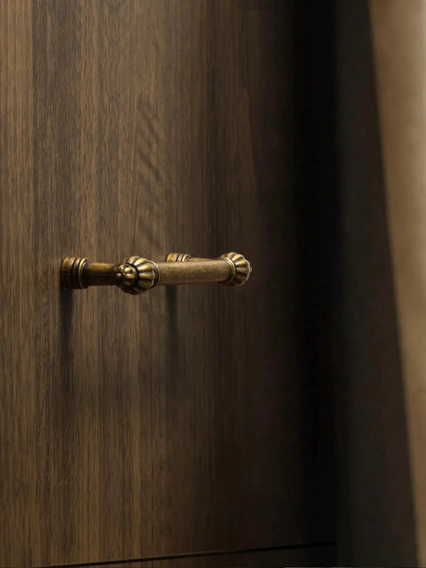 Antique Brass Zinc Alloy Cabinet Pulls Three And Three Quarters Inch Hole Center Classic Vintage Drawer Handles on wood surface
