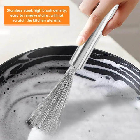 Hand using a stainless steel dish brush with high bristle density, scrubbing a soapy pan, ensuring no scratches on kitchen utensils.