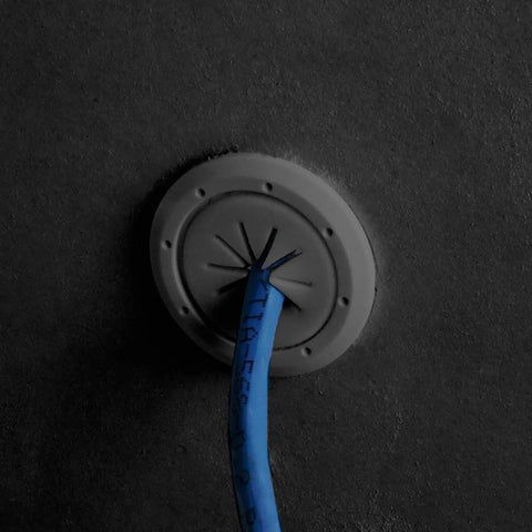 Round gray mini spring-lock cable pass-through port with blue cable inserted.