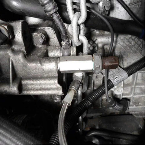 Stainless steel 1/8 NPT oil pressure sensor tee adapter installed on engine with hoses and wiring