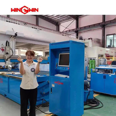 Person standing next to a blue waterjet cutting machine with a control panel in an industrial setting.