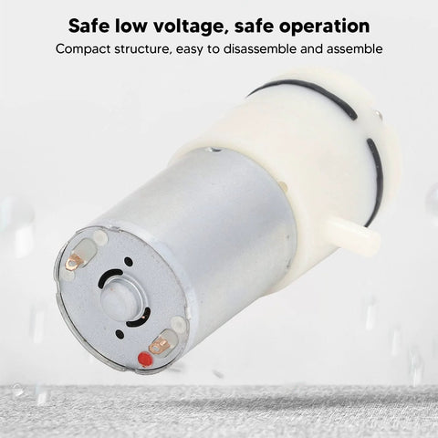 Miniature 6V vacuum pump with aluminium body and white plastic mounting, front view.