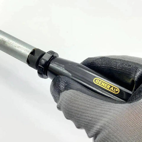 Compact Three Quarters Inch Hand Reamer And Countersink held in gloved hand, showing tool's steel cutter and handle with brand logo