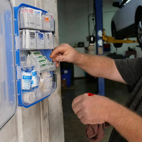Man using OSHA Compliant All Purpose First Aid Kit For 100 People Perfect For Worksite Office Home And Car in auto shop