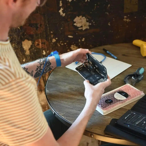 Person using Portable Anti Static Mat With ESD Pad And Wrist Strap Grounding Cord For Electronics Repair From iFixit in home setting