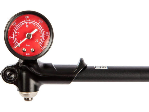 Fork/shock pump with red gauge, black body, silver valve, 300 psi max for bicycle suspension.