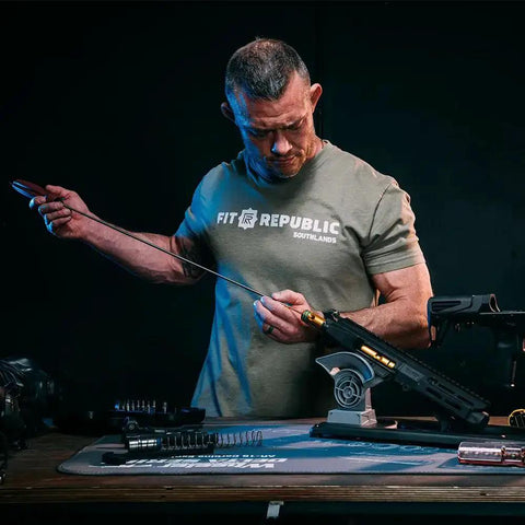 Deluxe Carbon Fiber Cleaning Rod For.27 To.45 Caliber Rifles, 40 Inch Length, in use for gun maintenance on a workbench