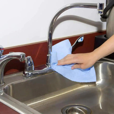 Person cleaning sink with Blue V40 Value Series Center Pull Wiper Sheets All Purpose Disposable Cleaning Towels 10 X 11.5 Inches Roll Of 200