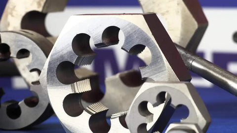 Close-up of Six Piece NPT Pipe Die Set For Rethreading In Carbon Steel Hex Dies 1/8 To 1 Inch Right Hand Cut on blue background