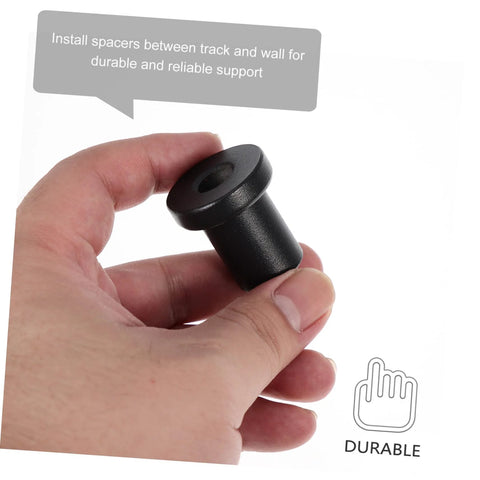 Hand holding a black carbon steel spacer from a four pack replacement carbon steel track spacers set for barn doors.