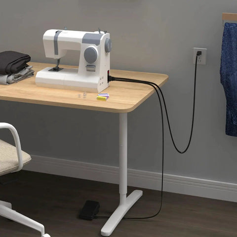 Sewing machine pedal and power cord for Singer; white device on wooden desk, plugged into wall outlet
