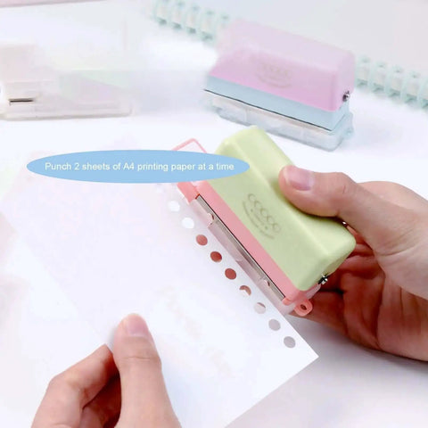 Using Grab And Go 5 Hole Paper Puncher Mini Handheld Circle Punch Tool for A4 A5 B5 paper sizes in a home office setting.
