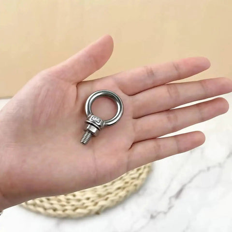 Hand holding 10 Pack M4 Eyebolt With Nut Stainless Steel Beefy Heavy Duty Screw Eye Bolt with 4mm thread, 11mm shank, ring shoulder.
