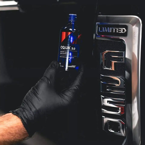 CQUARTZ UK 3.0 Ceramic Coating Kit For Cars Bonds To Paint Glass Metal held near a vehicle's Limited F250 badge