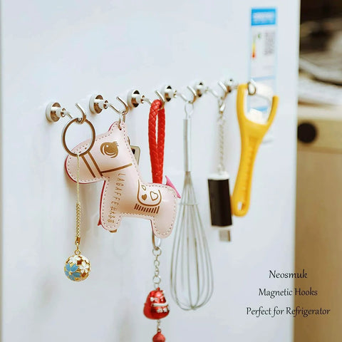 Refrigerator with multiple magnetic hooks holding kitchen utensils and decorative items, highlighting versatility and organization.