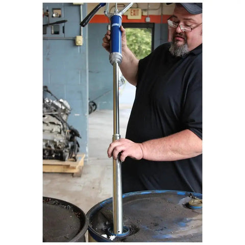 Person using Lincoln 1340 Lever Action Barrel Pump For Industrial And Automotive Lubrication And Fluid Transfer on drum