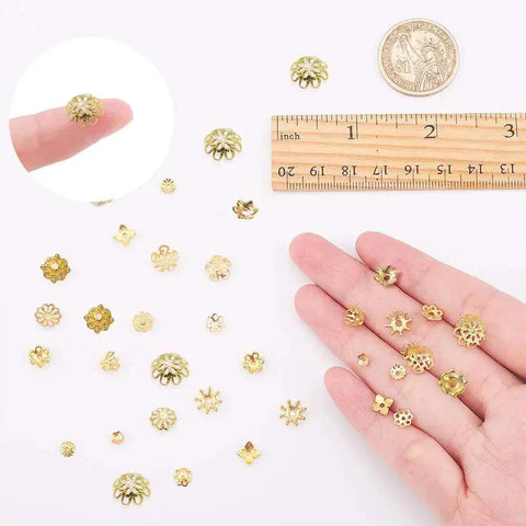 Golden Filigree Flower Bead Caps Set With 240 Pcs 12 Unique Brass Petal Ends for DIY jewelry making shown with a ruler and hand