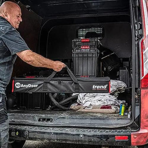 Man loading a Butt Hinge Template Kit With Fully Adjustable Router Jig into a van with storage boxes