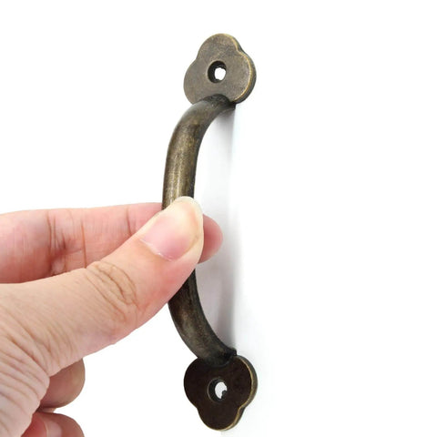 Hand holding 12 Pack Barn Door Handles Rustic Gate Pulls Bronze Metal Hardware Includes 24 Screws For Cabinet Garage Closet Drawer
