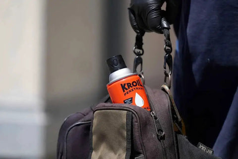 Person holding a bag with Aerokroil Penetrant Rust Penetrating Lubricant And Corrosion Inhibitor Oil For Chains Hinges And Stuck Metal Parts visible.