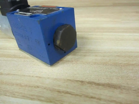 Close-up of Solenoid Directional Spool Valve 4WE6D62/EG24N9K33L/62 PN R978020512 Size 6 on wooden surface