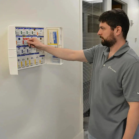 Person using OSHA Compliant 50 Person Workplace First Aid Kit With 245 Pieces In Large Plastic Cabinet Featuring SmartCompliance SmartTab ezRefill System.