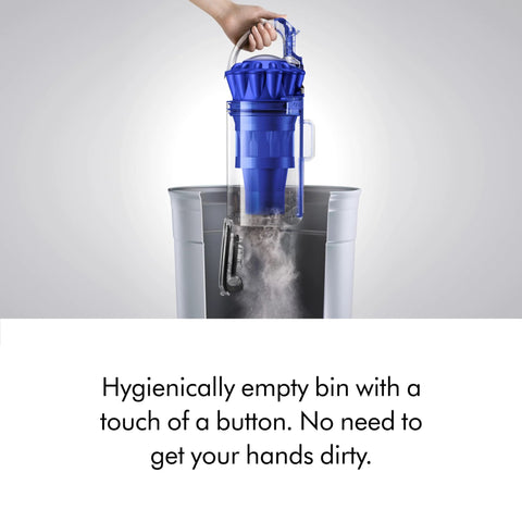 Dyson Ball Animal Total Clean upright vacuum with blue canister being emptied into a trash bin