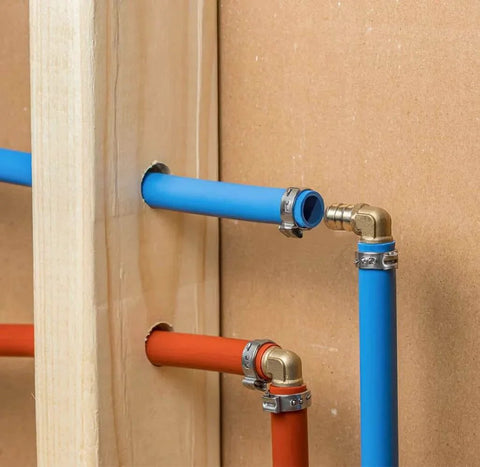 10 Pack Brass PEX Elbow Fittings One Half Inch 90 Degree For PEX Tubing Durable Potable Water Approved SDWA 2014 Compliant Plumbing Connectors Set Perfect For Home Renovation And New Installations In Indoor Or Outdoor Plumbing Projects, installed in blue and red PEX tubing in wall setup.