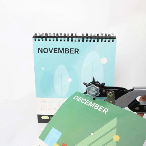 Multi Function Hole Punch Plier Set With Storage Case shown punching holes in a calendar page for paper crafts and DIY projects