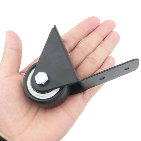 Hand holding Two Pack Universal Right Angle Fixed Casters 1.5 Inch Wheels Black for Luggage Trolleys Bags and Speaker Carts Durable Plastic and Metal Construction with L Shaped Plate Includes Mounting Screws for Easy Quick Installation