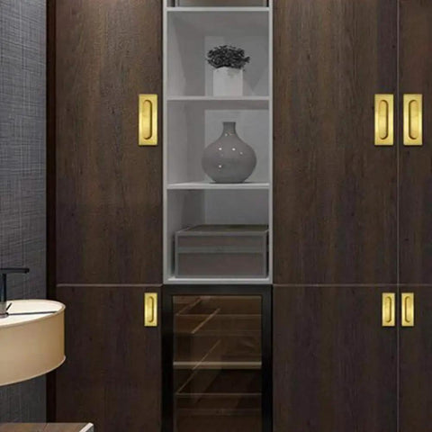 Installed Recessed Brass Cabinet Handle for Kitchen Cabinets, polished finish, hidden flush mount, shown on dark wood cupboards.