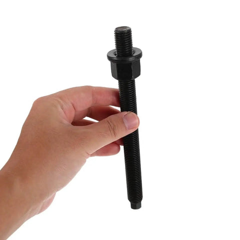 Hand holding a bolt from the Crankshaft Pulley Removal Tool Gear Puller Kit For Engine Timing Belt And Drive Pulley Disassembly