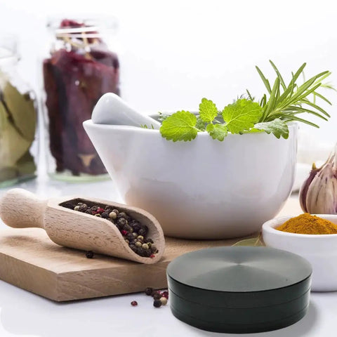 4 Inch Herb Grinder For Spices And Herbs, Zinc Alloy Low Profile 1 Inch Tall Design next to herbs and spices in a kitchen setting