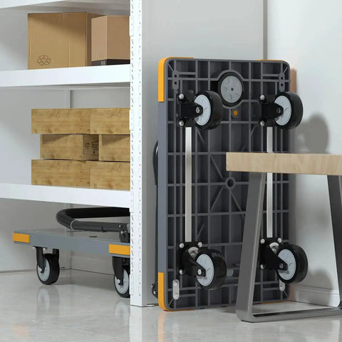 Heavy Duty Folding Push Cart With Reinforced Platform stored upright next to shelves, showcasing swivel wheels and grey plastic plate.