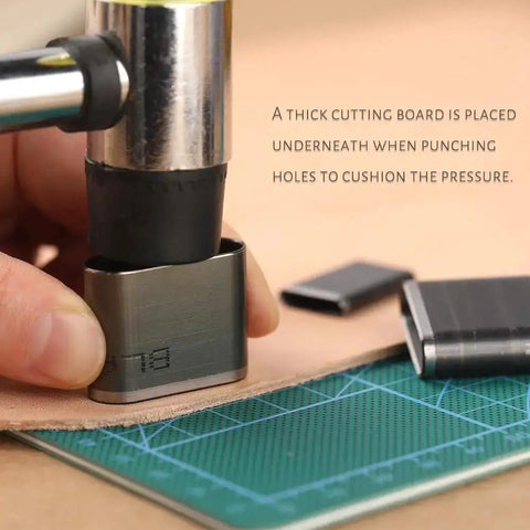 Close-up of using a 52 Shape Style Leather Hole Punch Tool Set With 52 Shapes on a leather strip, featuring a hammer and cutting mat.