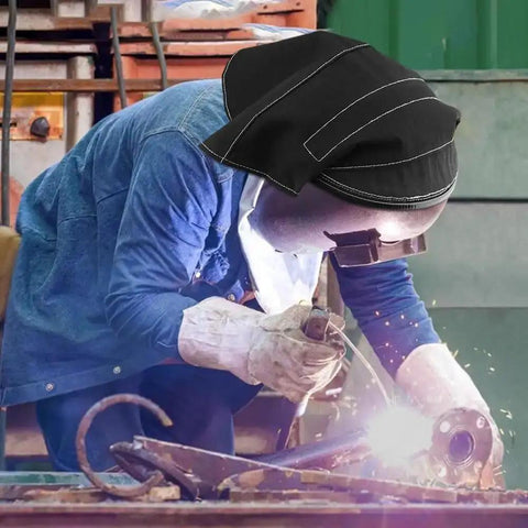 Worker welding with helmet showing extended welding helmet cover with press fit seal for pro grade protection in use.