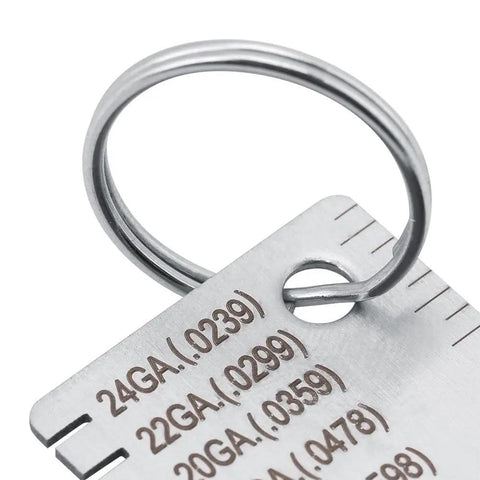 Close-up of a stainless steel thickness gauge for welding and metal fabrication, showing gauge measurements 24GA to 20GA.