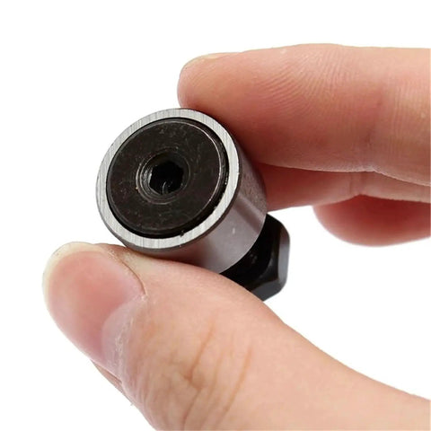Close-up of Cam Follower Needle Roller Bearing Set 2Pcs KR16 CF6 held between fingers, showcasing 16mm roller, corrosion-resistant steel.