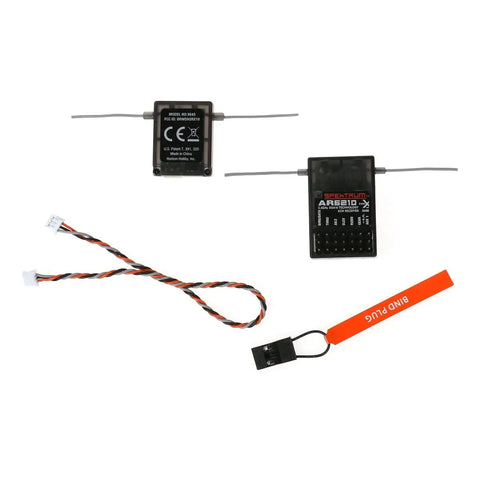Ar6210X DSMX 6 Channel RC Receiver Built To Work With JR And Spektrum Transmitters shown with antennas, bind plug, and cables.