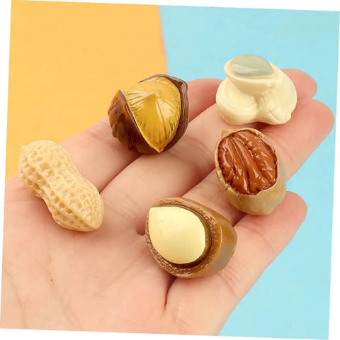 Hand holding 20 Pcs Resin Mini Food Toys Nuts Set For Dollhouse DIY Crafts, Realistic Peanut And Nut Decor for tiny kitchen.