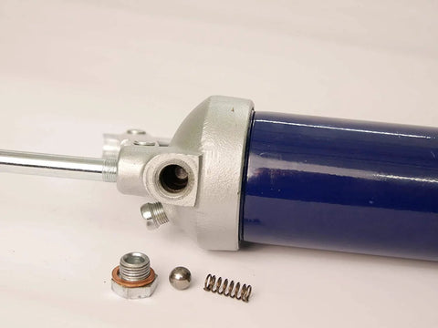 Lincoln 1142 grease gun with blue cylinder and cast-iron pump head; loose nut, copper washer, ball, spring.