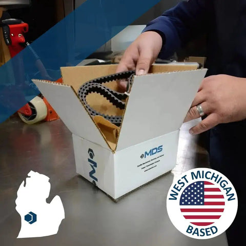 Person opening box with logo, containing industrial belts, "West Michigan Based" label visible