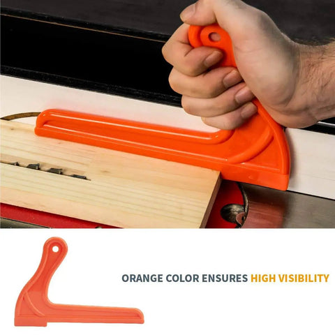 Hand using an orange push stick from the Table Saw Safety Accessories 6-Piece Set With Push Block, Push Sticks And Taper Jig For Router Tables.