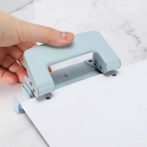 Beefy 6mm Two Hole Punch Handheld Paper Punch in use, ergonomic non-slip grip, punching paper on a marble surface