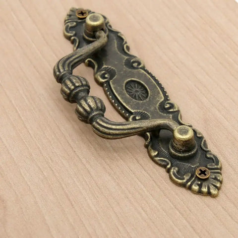 Close-up of Six Pack Vintage Antique Brass Bail Pulls for drawers, featuring zinc alloy with distressed finish and retro rustic hardware.