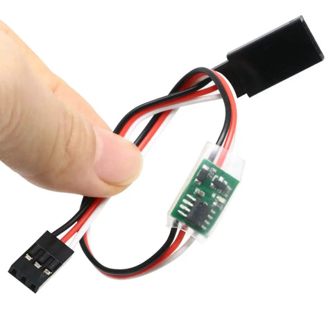 Hand holding Ultimate Slow Servo Reducer Delay Module for RC Models 5 to 6 Volt, showcasing wiring and connectors for aircraft use.
