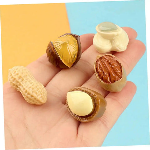 Hand holding Miniature Resin Nut Ornaments Set For Dollhouse Food Decor, Realistic Tiny Nut Models For Crafts And DIY Projects