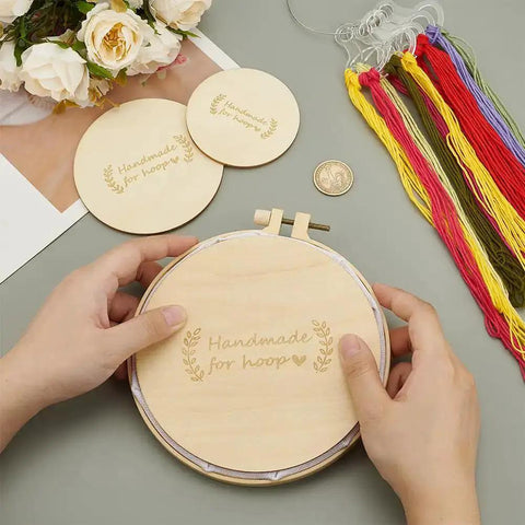 Hands holding a wooden embroidery hoop with "Handmade for hoop" inscription. Six Pcs Wooden Backing Plates For Finishing Embroidery Hoops In Three Round Sizes 5.9In, 3.9In And 3In, Perfect For Christmas Ornament Making And DIY Sewing Craft No Hanging Ring Included are visible.